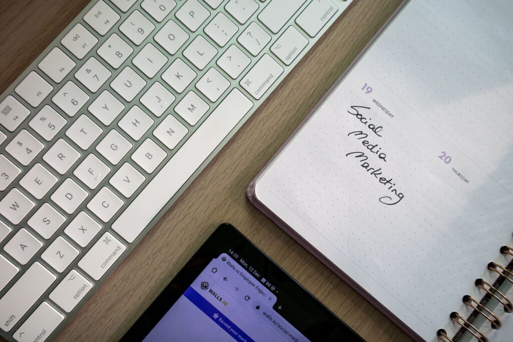 Notebook with Social Media Marketing note next to a keyboard and tablet